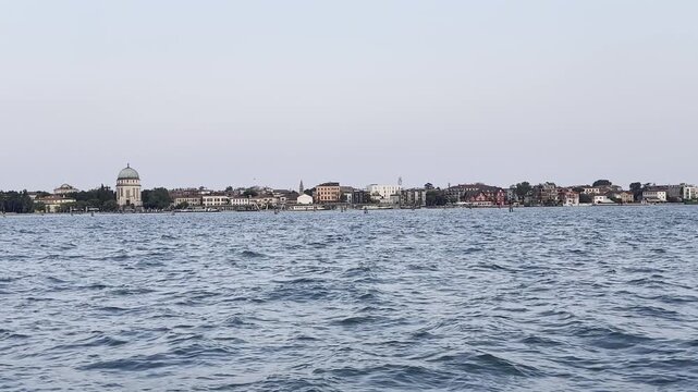 Panoramic city skyline over ocean waves with clear sky