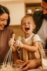 Family baking in kitchen laughing and having fun