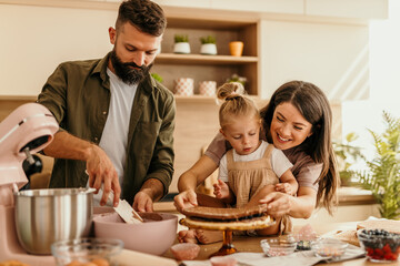 Family baking a cake together in kitchen