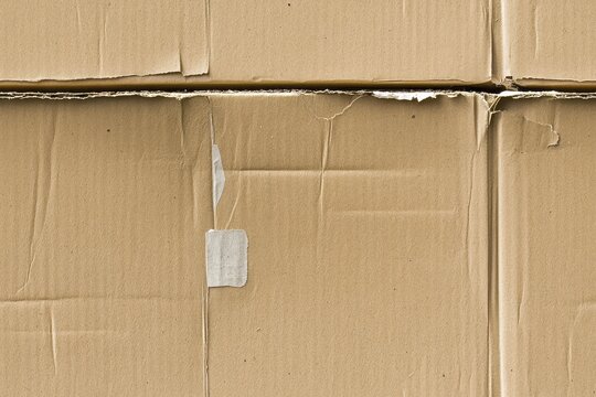 Close-up of stacked brown cardboard boxes with visible texture. Seamless pattern.