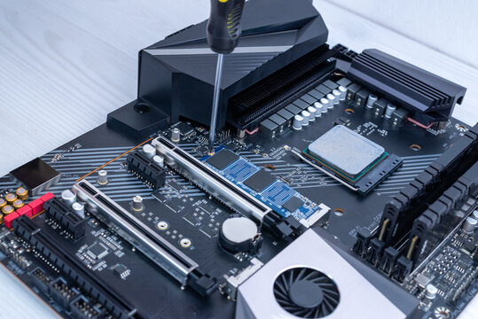 Securing m2 ssd on motherboard with screwdriver, computer storage installation and high speed nvme upgrade process