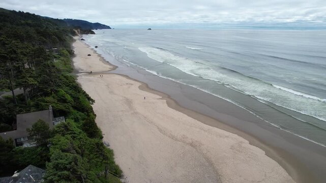 Aerial of Arcadia beach in the pacific northwest of Oregon. Drone push shot of waves crashing on to beach.