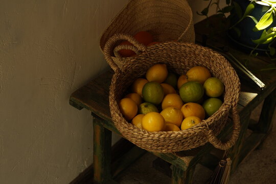 Cestas antiguas con limones en un entorno rural r&uacute;stico con taburete de madera, alimentaci&oacute;n, comida