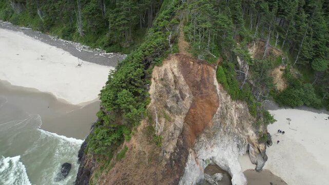 Aerial of Arcadia beach in the pacific northwest of Oregon. Pulling drone shot of large rugged cliffside.