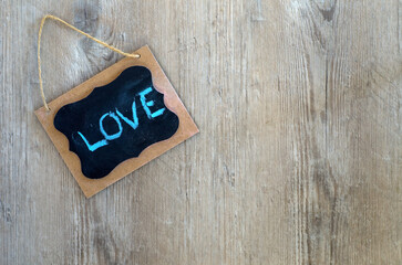 Love Note Written with Blue Chalk on a Small Message Board on a Wood Wall