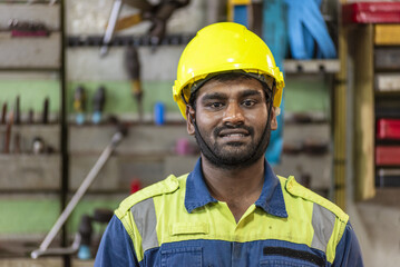 Close-up of a ship engineer in protective uniform inside an engine room workshop, with industrial background and copy space. Professional maritime worker during onboard maintenance. © Mariusz