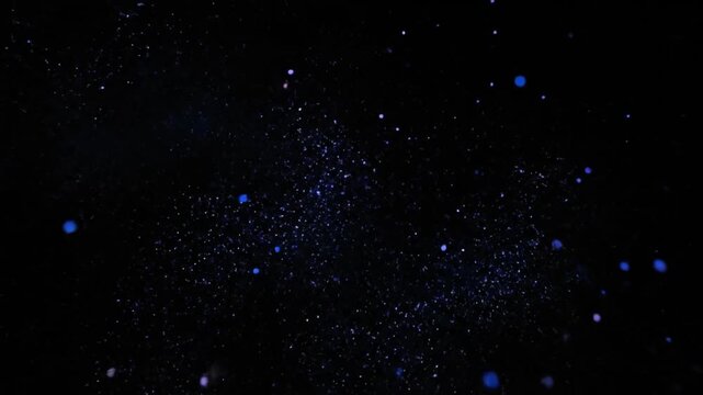Abstract lens particle motion loop, tiny glowing sparks drifting slowly in deep black space