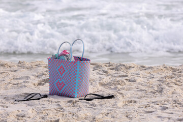 Beach Bag and Flip Flops Rests on the Sand While Waves Roll in at Gulf Shores, Alabama Beach During Sunny Afternoon