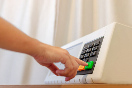 Urna eletr&ocirc;nica brasileira durante elei&ccedil;&otilde;es presidenciais, com eleitor pressionando o bot&atilde;o confirmar. Conceito de democracia, dever c&iacute;vico e processo eleitoral no Brasil.