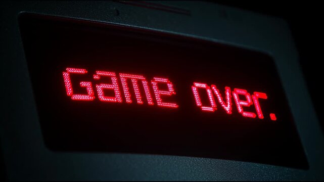 Close-up of a Dark Room With a TV Screen Showing Game Over in Red Text Multiple Times in Quick Succession