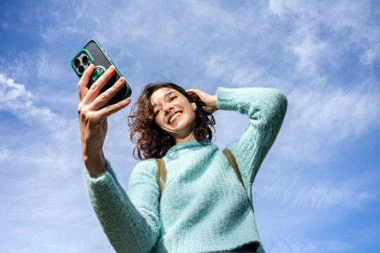 Young Woman Enjoying Sunny Day While Taking Selfie Outdoors