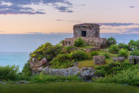 Mayan temple at sunset on tulum cliffs overlooking caribbean sea