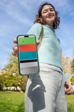 Young Woman Smiles While Holding Phone Outdoors on a Sunny Day