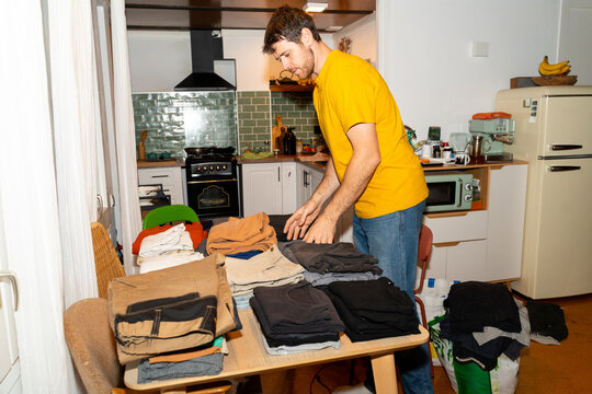 Man organizing clothes at home