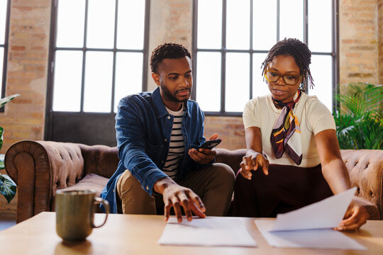 Business colleagues reviewing documents in casual office