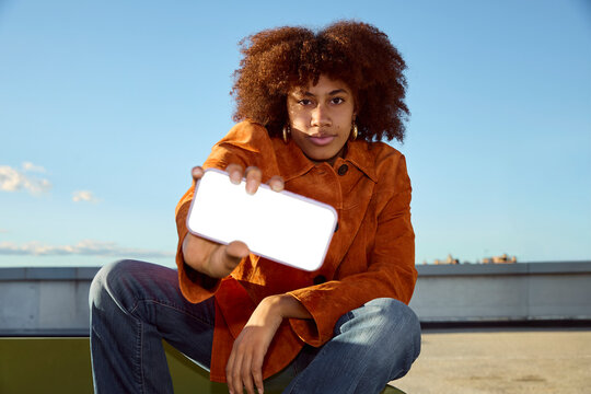 Woman holding smartphone toward camera