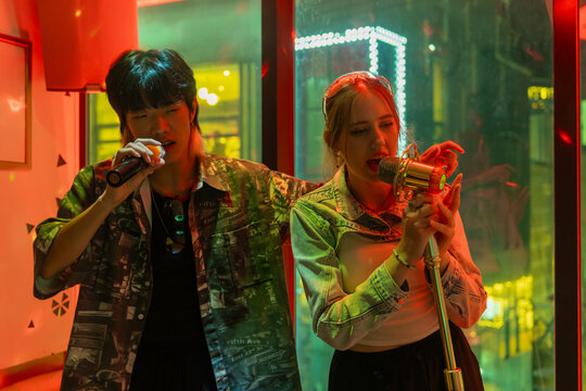 Friends Enjoying Karaoke Night in Vibrant City Setting