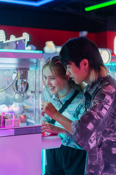 Exciting Moments at an Arcade Machine With Friends in the Evening