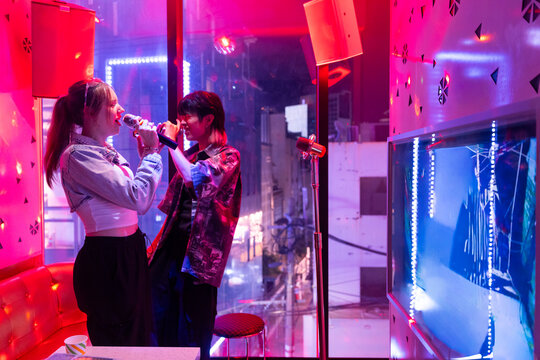 Friends Enjoying Karaoke Night in a Vibrant Bar Setting