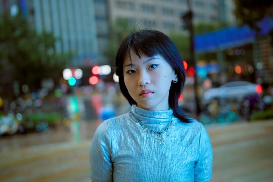 Urban Portrait of a Woman in Shiny Top on a Busy Street