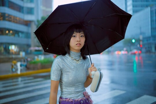 Fashionable Young Woman With Umbrella in City During Rain