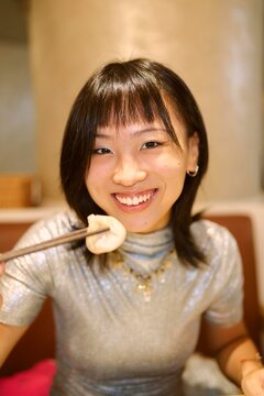 Woman Enjoying Dumplings at a Cozy Restaurant During the Evening