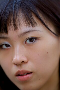 Close-up Portrait of a Young Woman With Dark Hair Outdoors