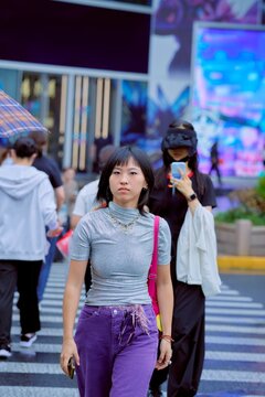 Young Woman Crossing a Busy Street in the City During Daytime