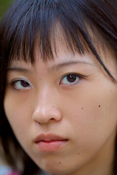 Intense Gaze of a Young Woman in a Tranquil Setting During Dusk