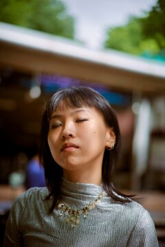 Young Woman Enjoying a Moment of Calm Outdoors During Daytime