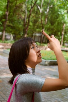 Woman Marvels at Nature While Pointing Phone Towards the Trees