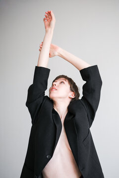 Model Poses Elegantly in a Black Blazer on Neutral Background