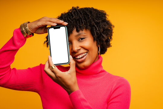 Pretty woman with phone with blank screen in studio