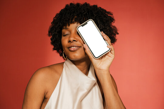 Stylish woman with a smartphone with blank screen in a studio