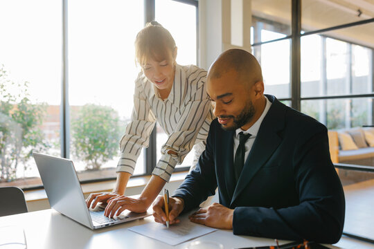 Business colleagues collaborating on contract signing in office
