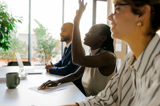 Businesswoman raising hand asking question in meeting