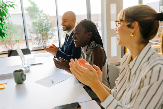 Business team clapping celebrating success during meeting