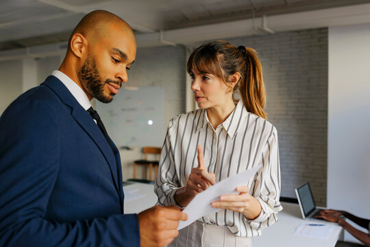 Business colleagues discussing project while looking at documents