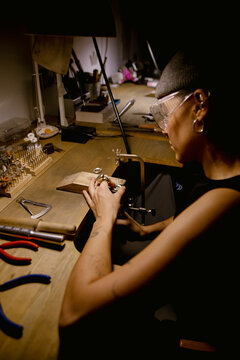 Goldsmith shaping metal with coping saw

