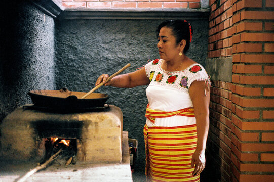 Film photo of a Woman stirring pot in traditional kitchen setting