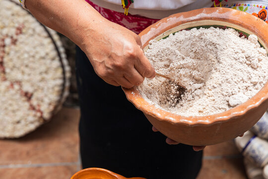 Woman Mixing corn flour or pinole in Traditional Bowl 