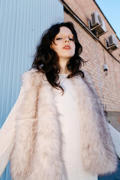 Woman wearing fur vest posing outdoors
