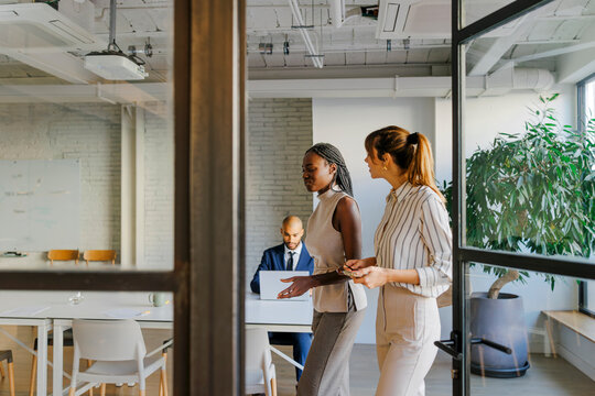 Businesswomen walking through office discussing project