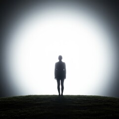 Obraz premium Silhouetted Woman Facing Bright Light on Hilltop