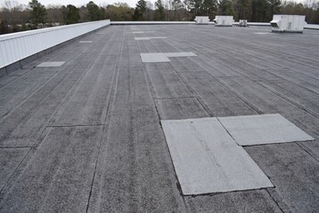 Fototapeta premium Flat commercial roof with modified bitumen surface and patches