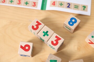 Wooden cubes with mathematical formula on table, above view