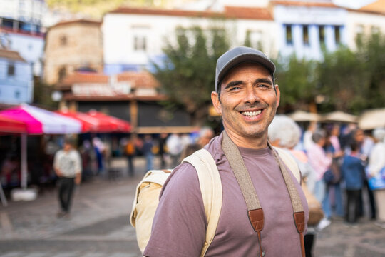 Man standing in Chefchaouen plaza surrounded by tourists