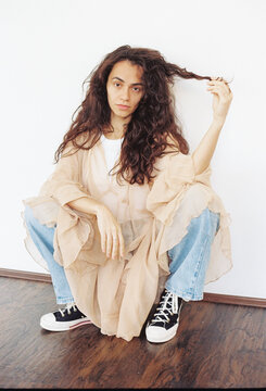 Young Woman Styles Outfit With Casual Flair in Creative Indoor Space