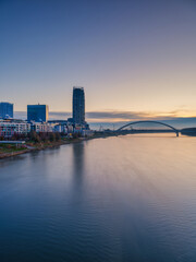Obraz premium Eurovea District and Apollo Bridge Over Danube River at Sunrise