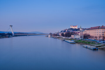 Naklejka premium Bratislava Castle and UFO Bridge Over Danube River at Dawn